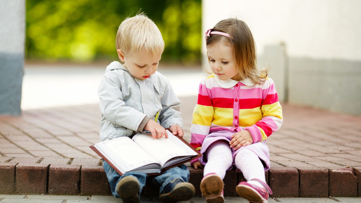 cute boy and girl reading a book